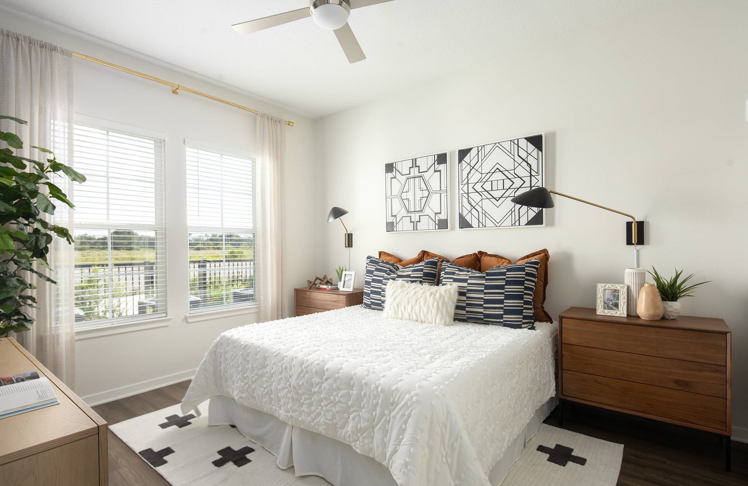 Alta Winter Garden's two-bedroom model presents a well-appointed bedroom with crisp white bedding and tasteful wall art.