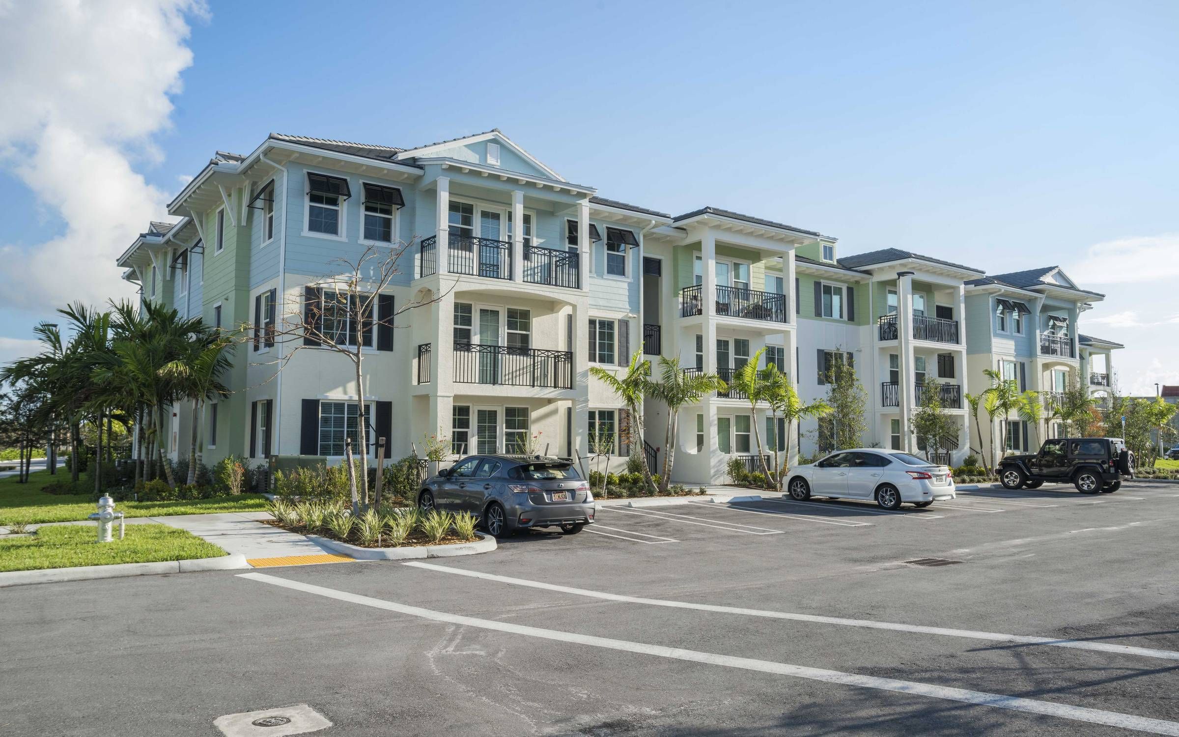 Delray Station apartment complex exterior with pastel-colored paint and beachy architecture.
