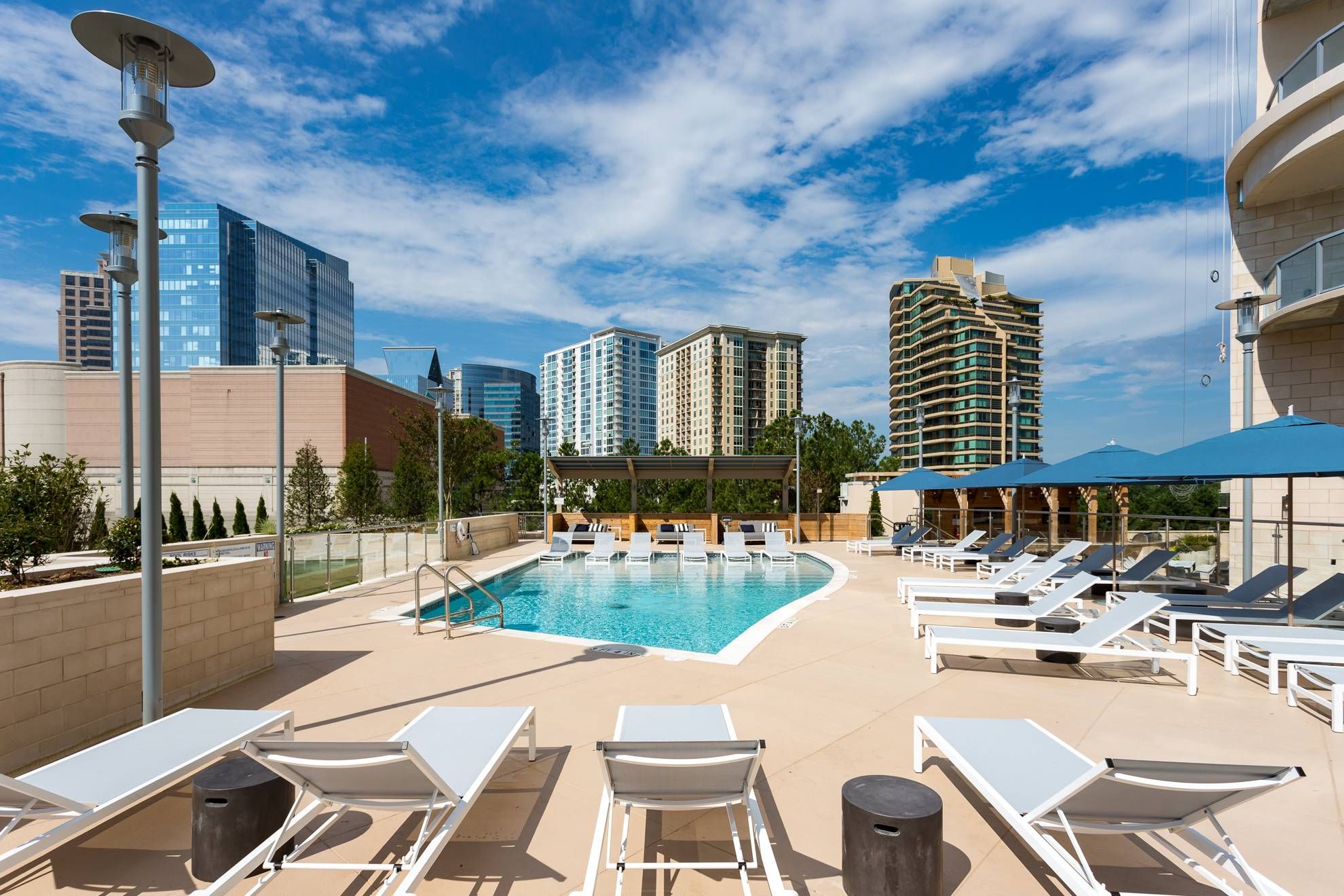The Huntley resident pool with lounge chairs overlooking city skyline.