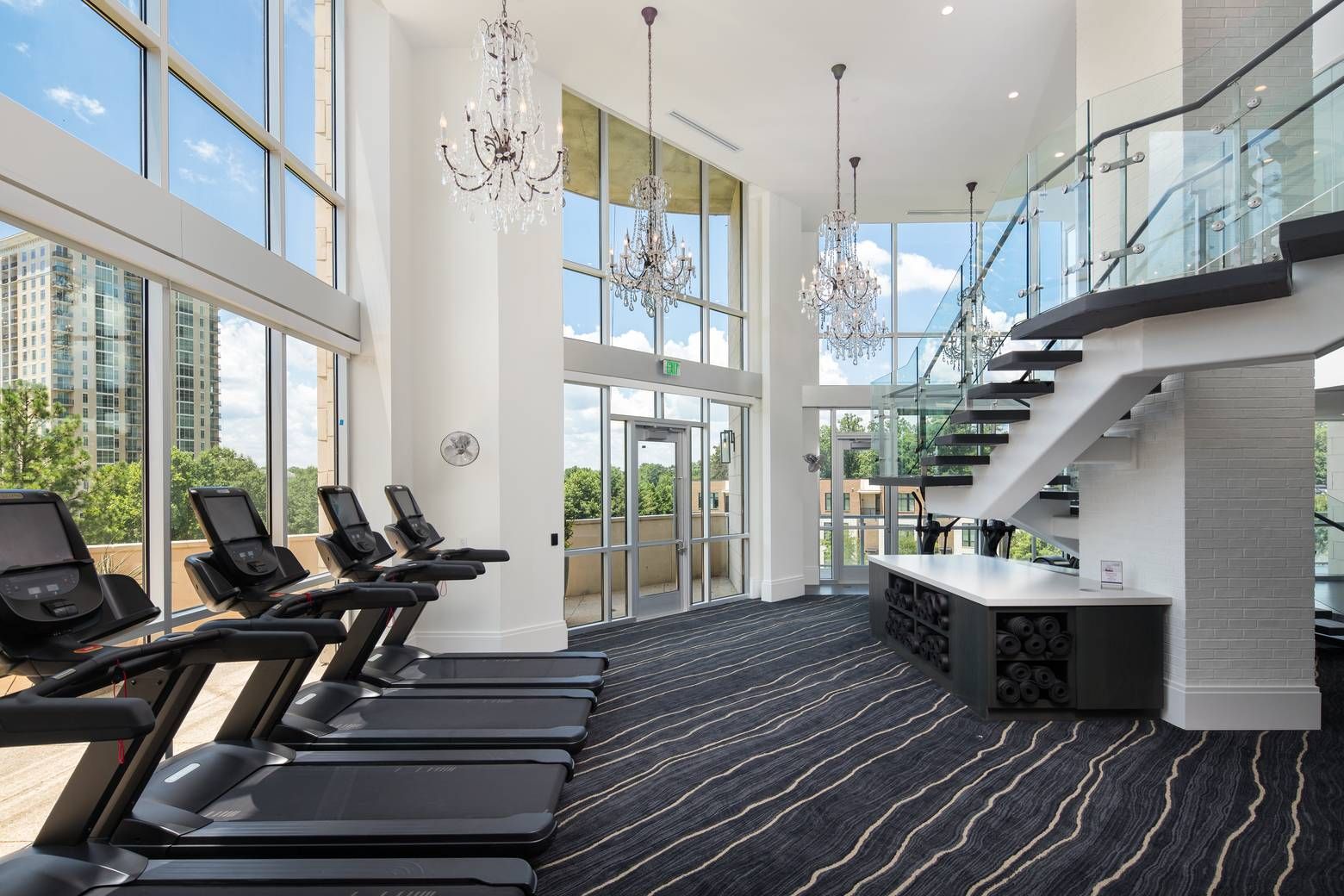 The Huntley luxurious fitness center with chandeliers and treadmills.