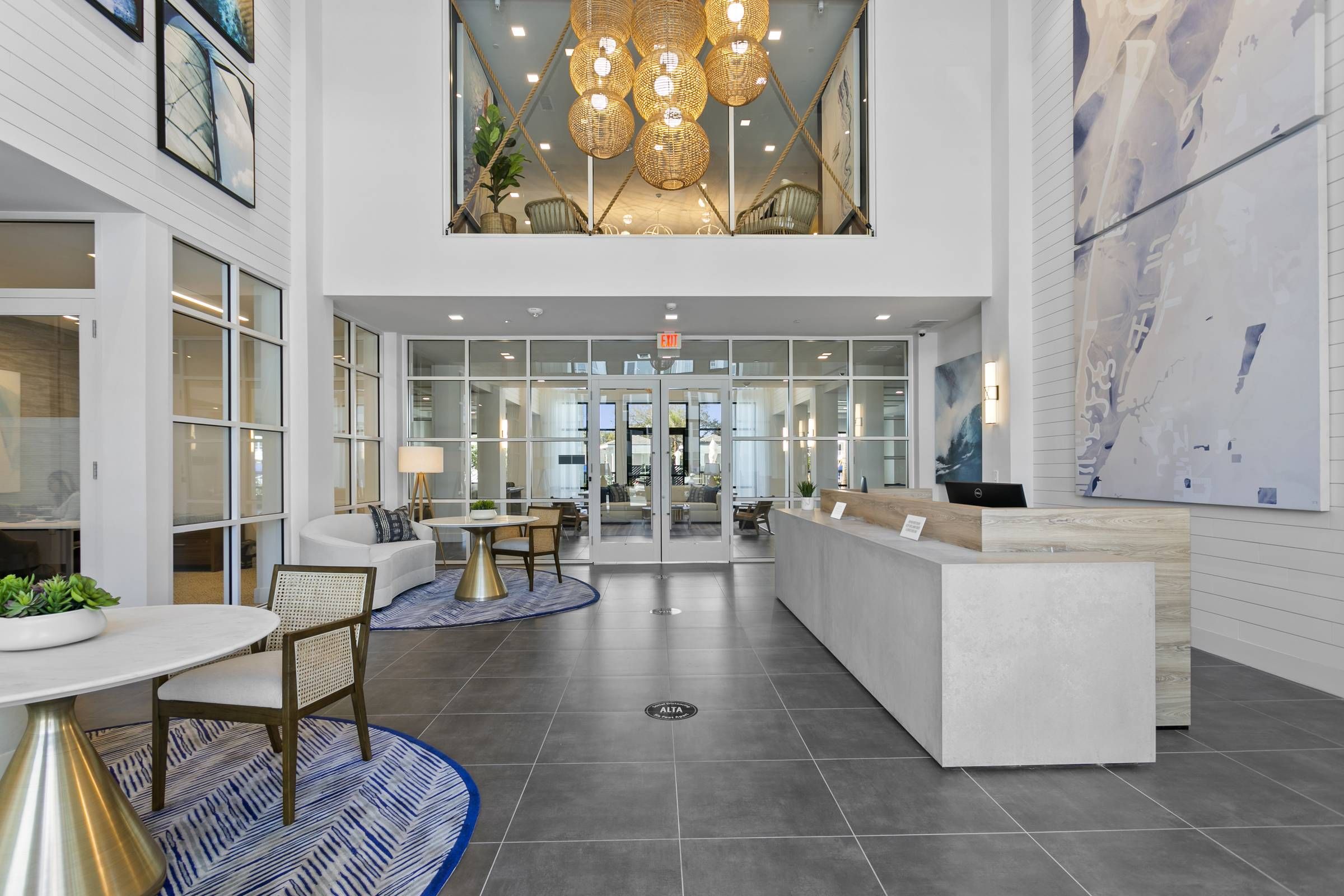 The grand entrance lobby of Alta Belleair with high ceilings, chic seating arrangements, and striking lighting, embodying a welcoming atmosphere.