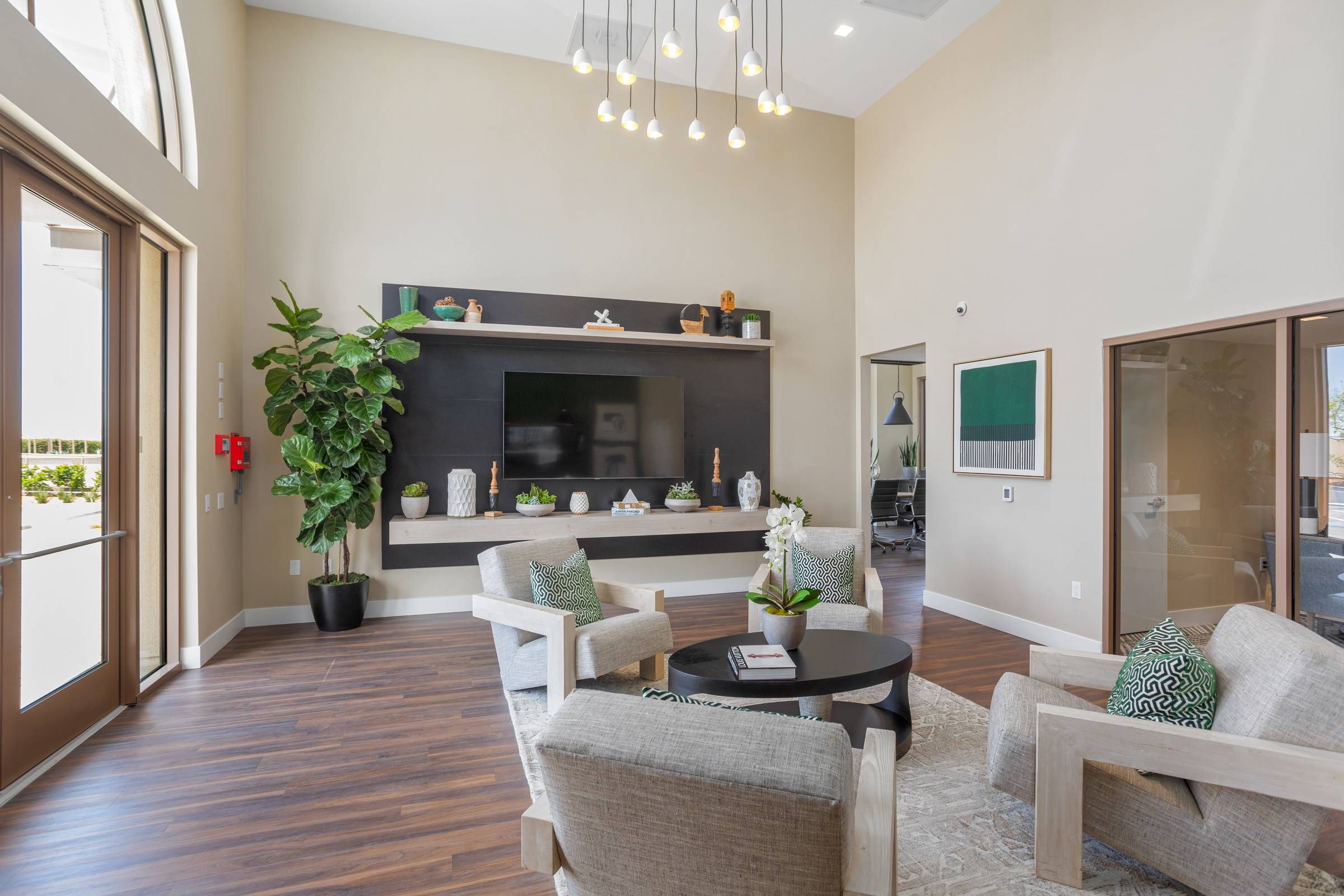 Alta Upland's open-plan living space shines with natural light from large arched windows, highlighting the elegant sectional sofa and contemporary kitchen in the backdrop.