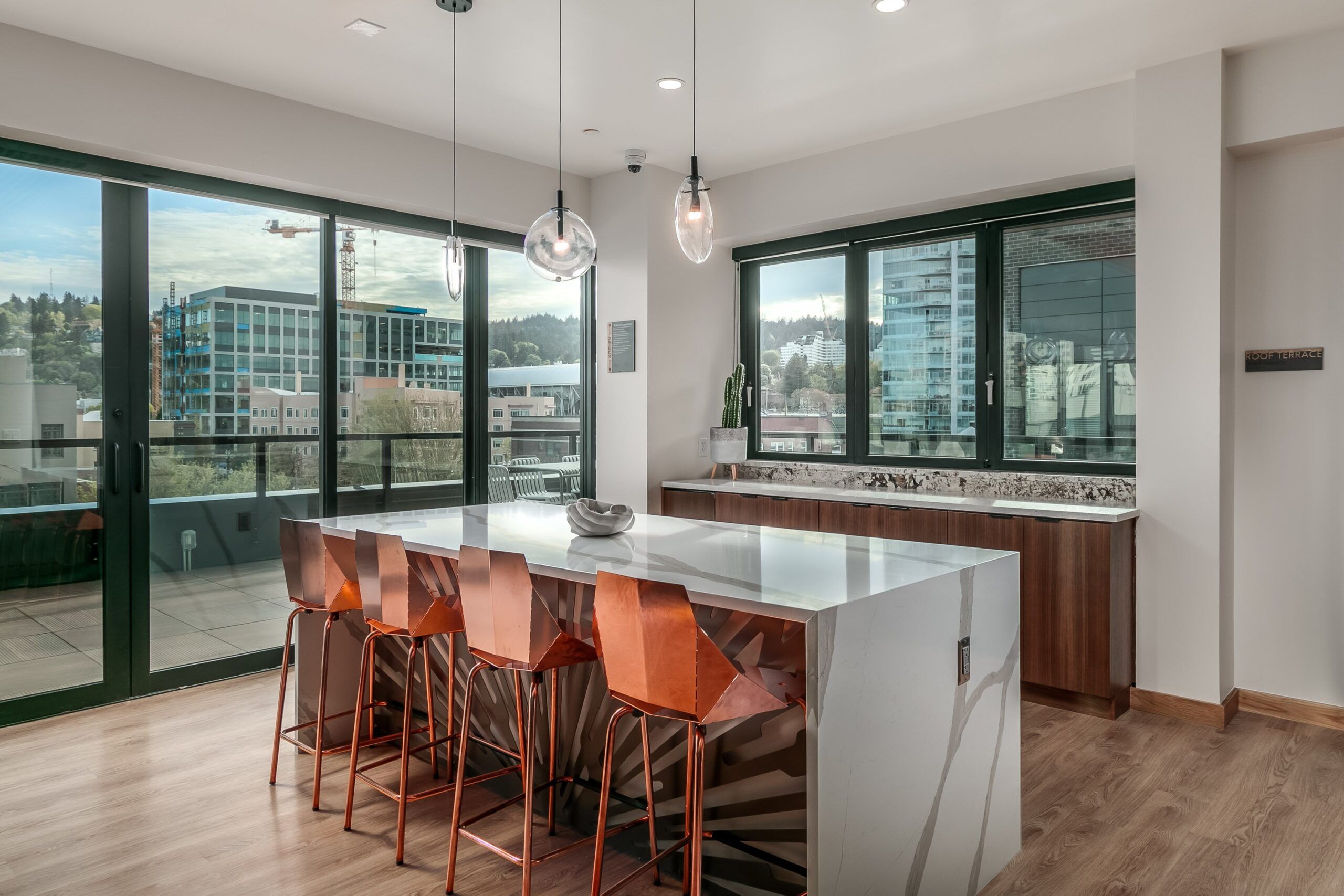 Alta Peak apartments amenity lounge with waterfall kitchen island and pendant lighting