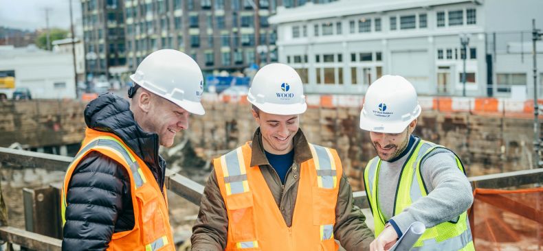 Trio of construction workers look at building plans.