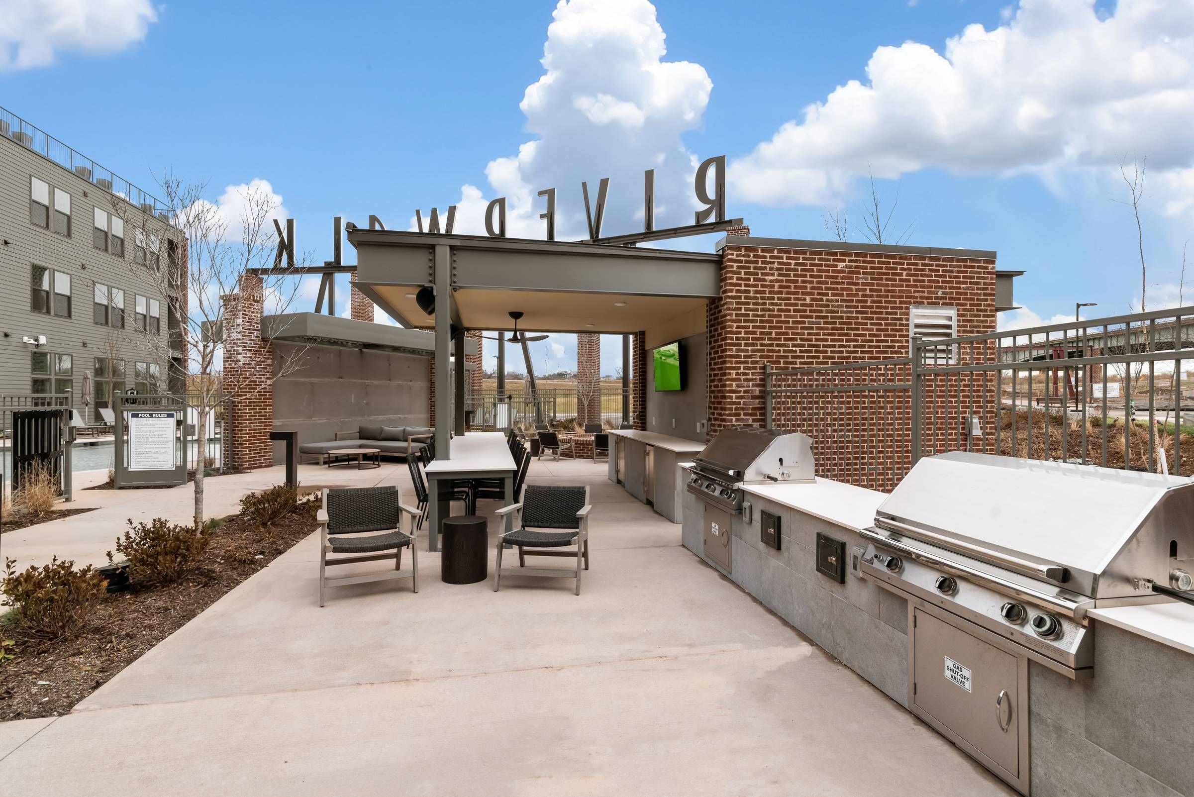 Alta Riverwalk outdoor grilling area with dining tables.