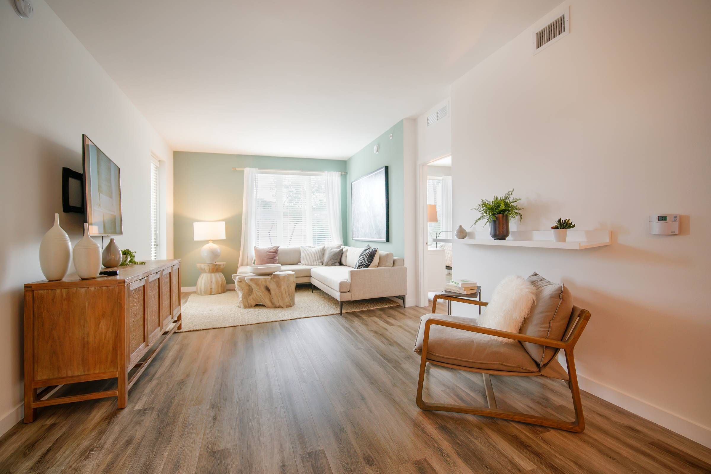 Bask open plan living area with hardwood floor and large window.