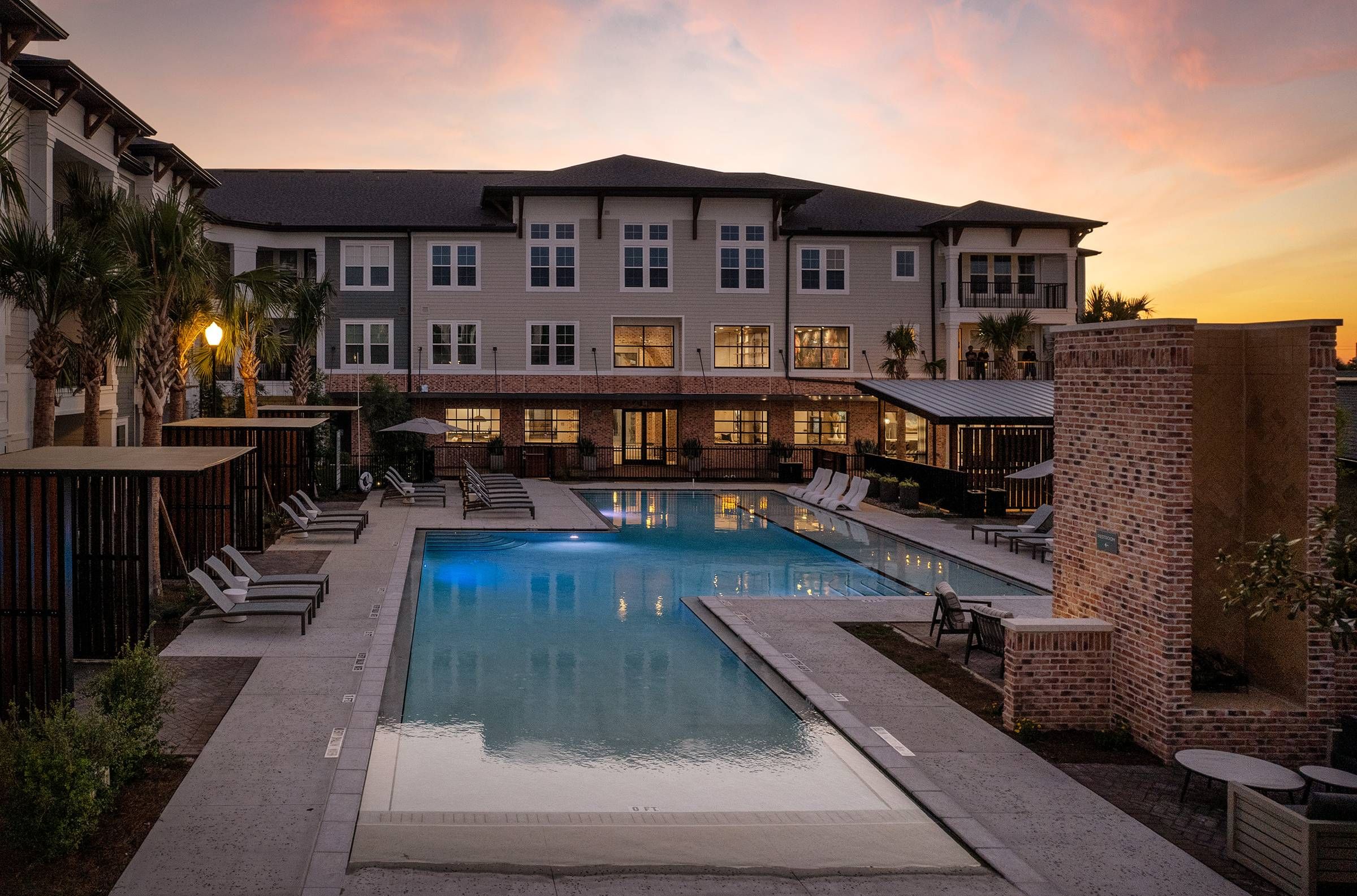 Alta Winter Garden's communal pool area captured at dusk, highlighting the pool's reflective water and the surrounding relaxation spaces.