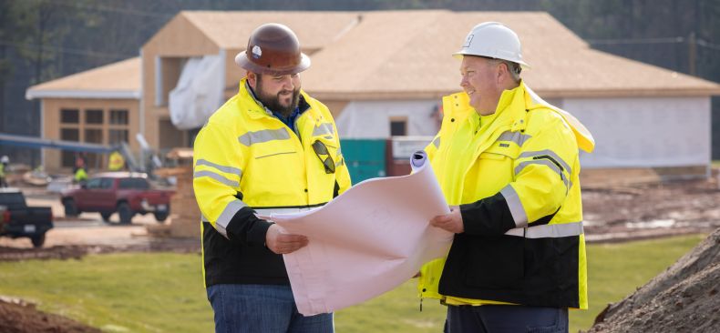 Trio of construction workers look at building plans.