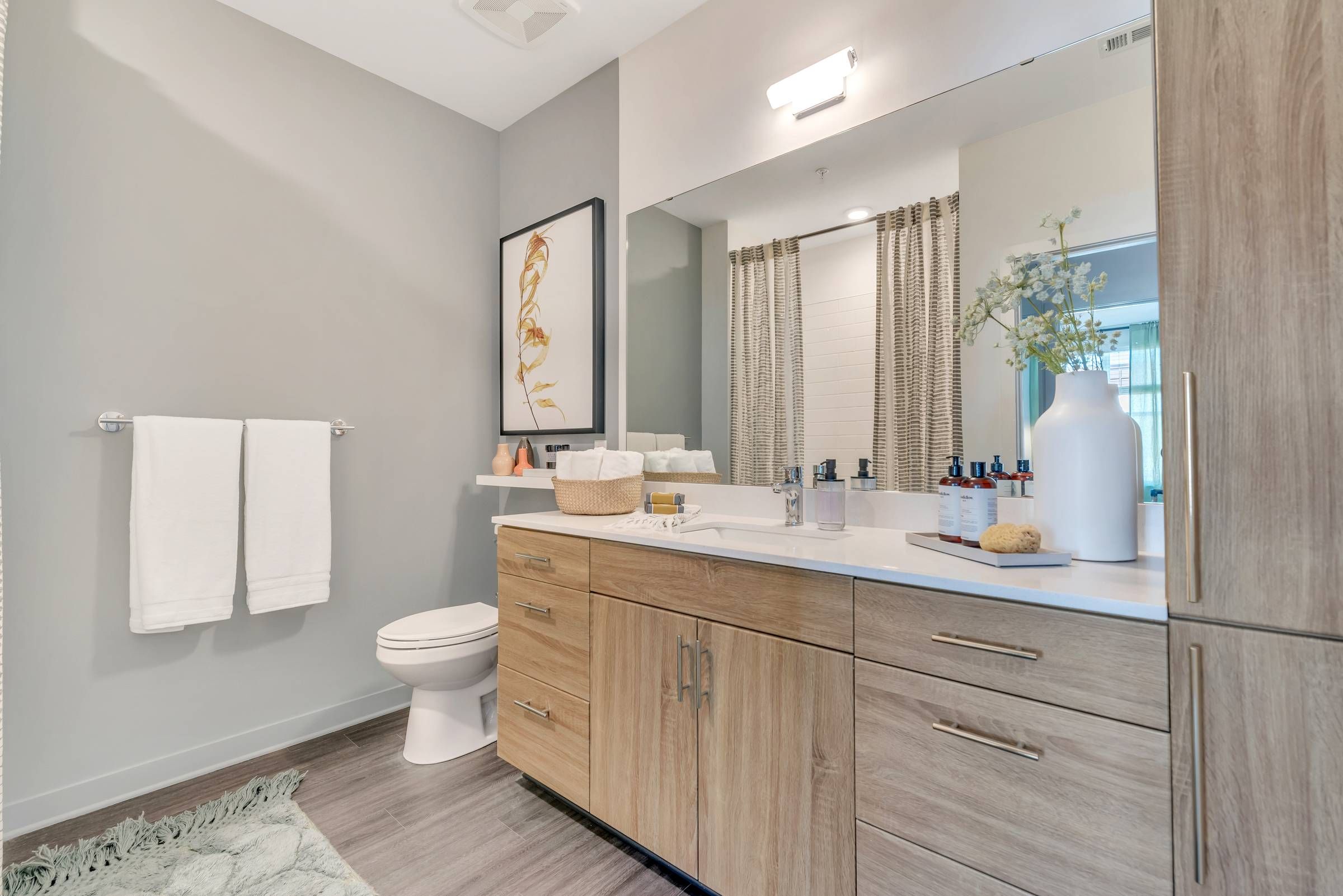 Alta Purl bathroom with ample cabinet space and chic wood finishes.
