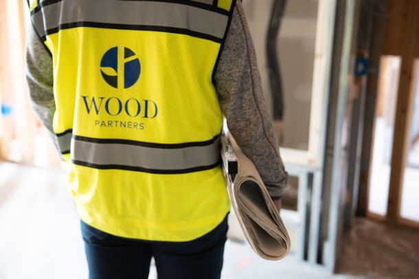 A construction team reviews blueprints together in a small room