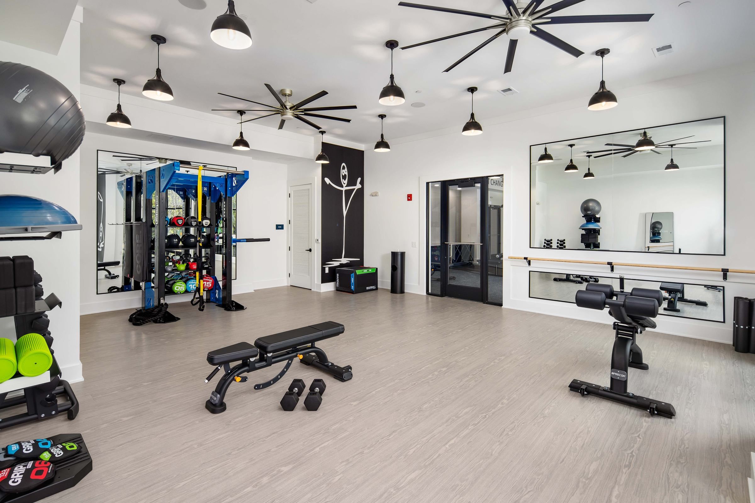 Alta Ashley Park's specialized workout room, featuring a black multi-gym station, colorful weights, and ample space for a variety of exercises.