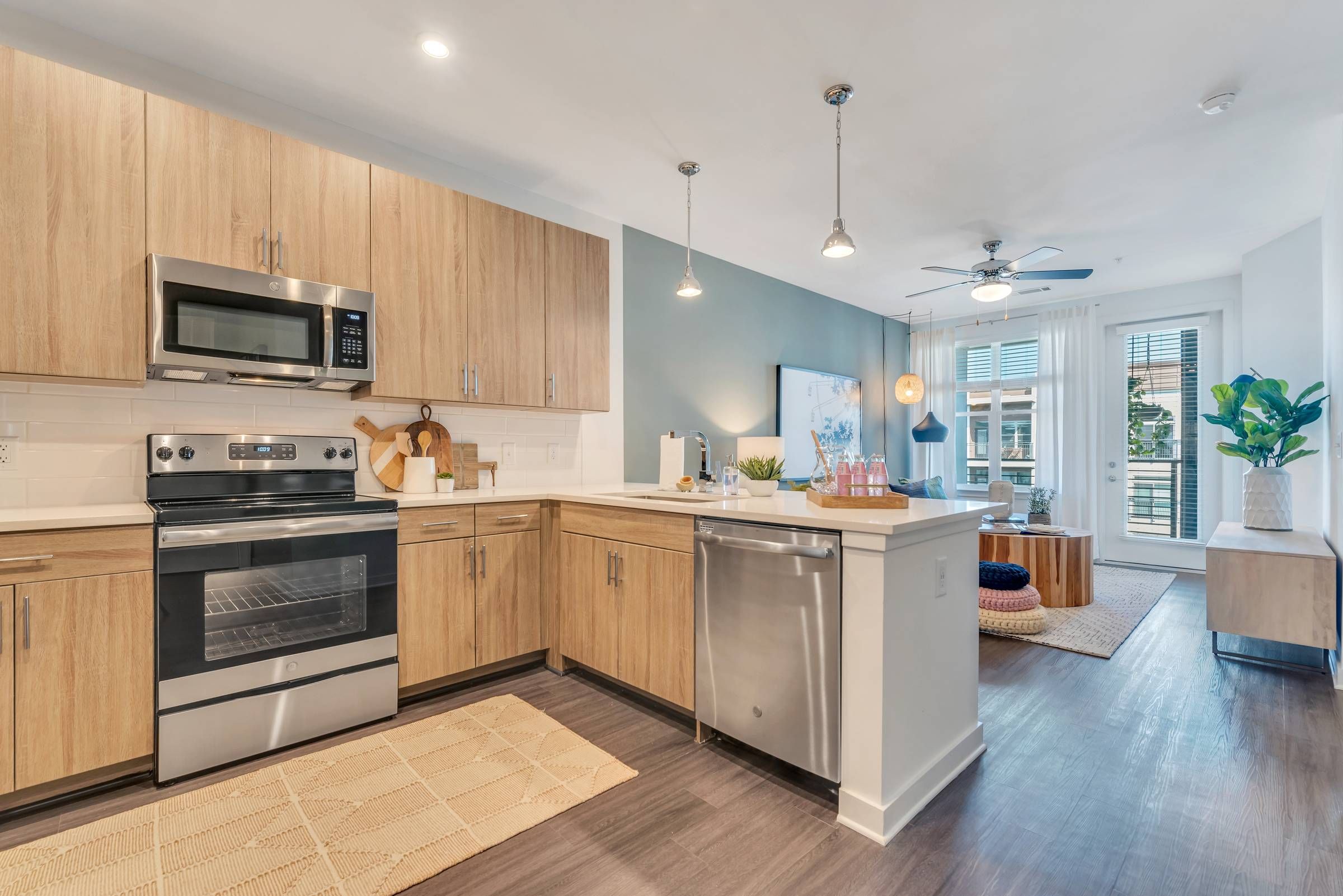 Alta Purl open floor plan kitchen with stainless steel appliances and wood finishes.