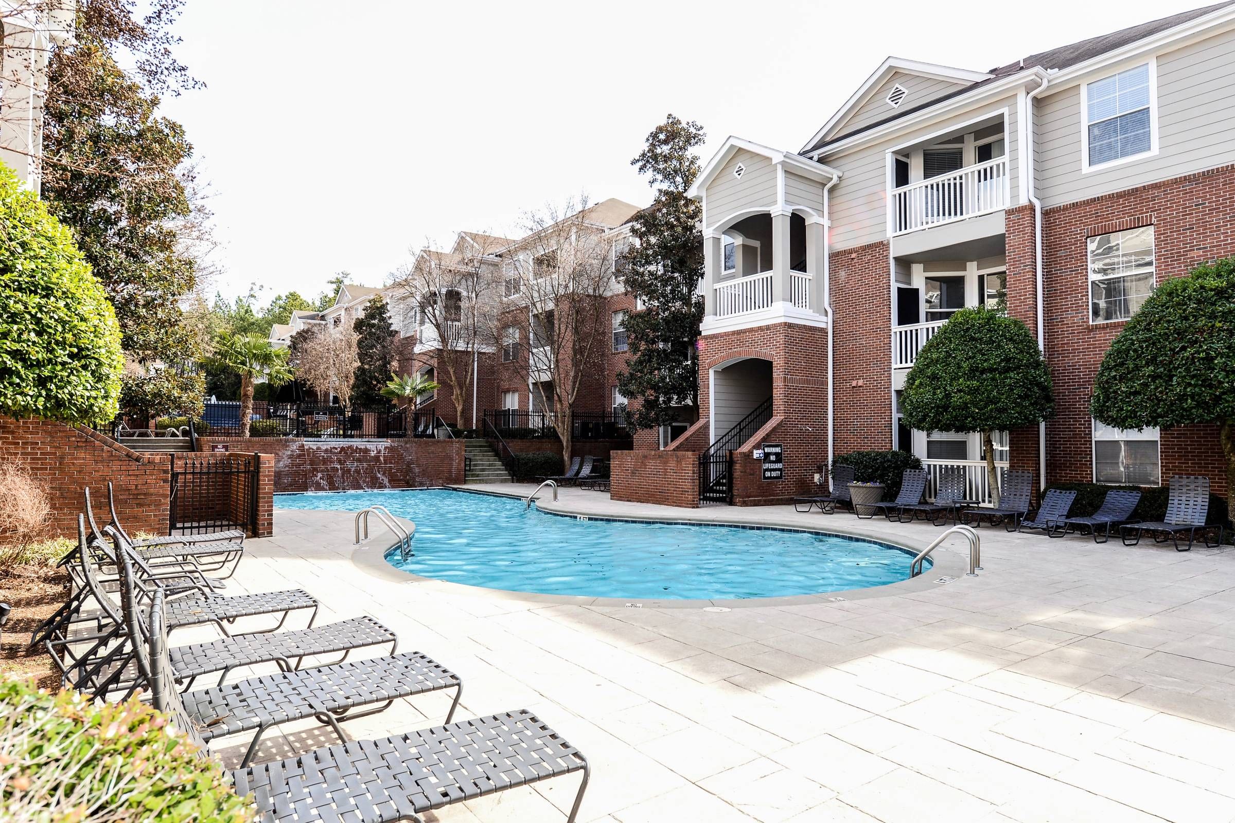 Altera Riverside apartments in front of community pool and lounge chairs.