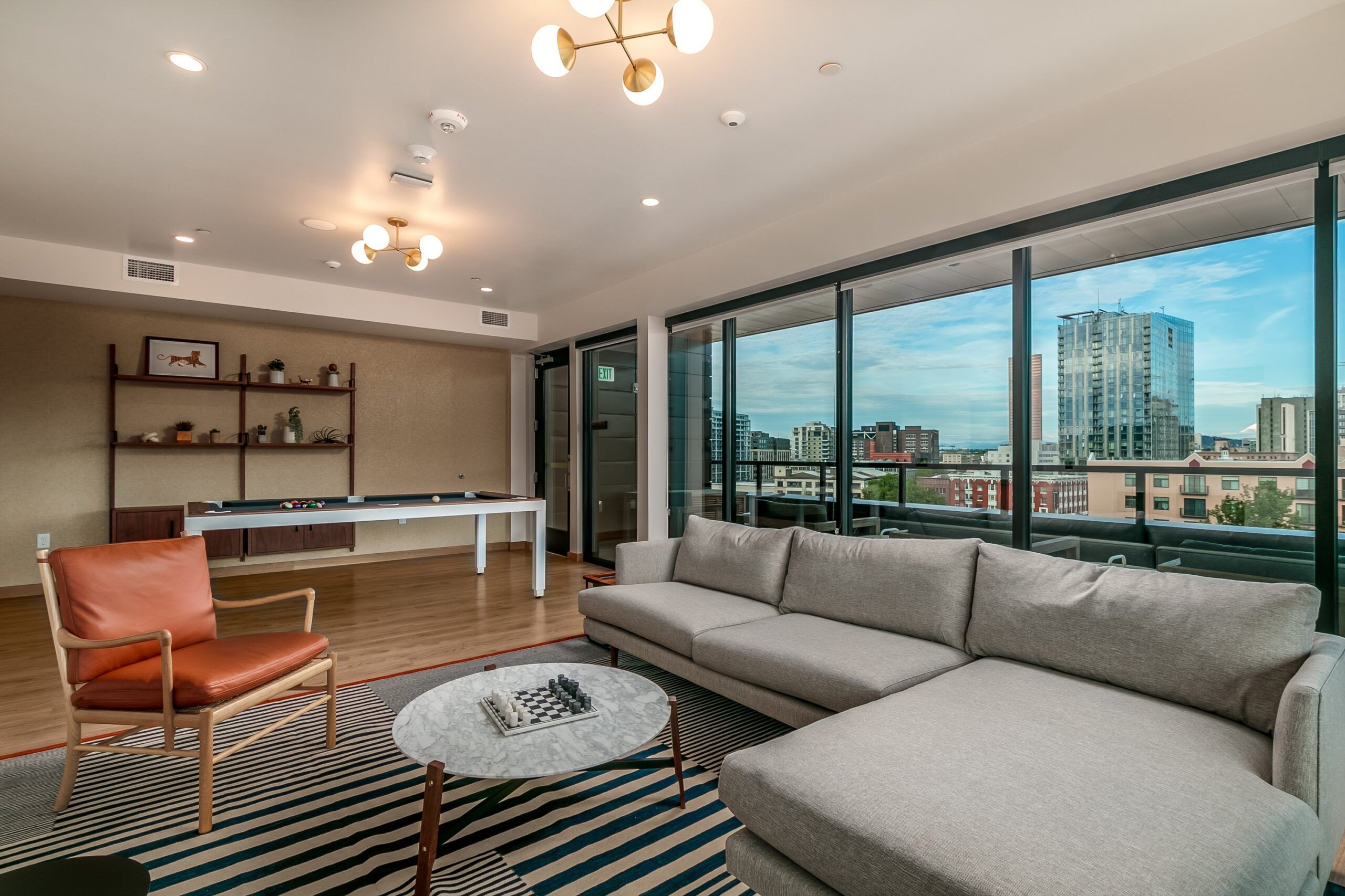 Alta Peak apartments amenity space with shuffleboard and large couch