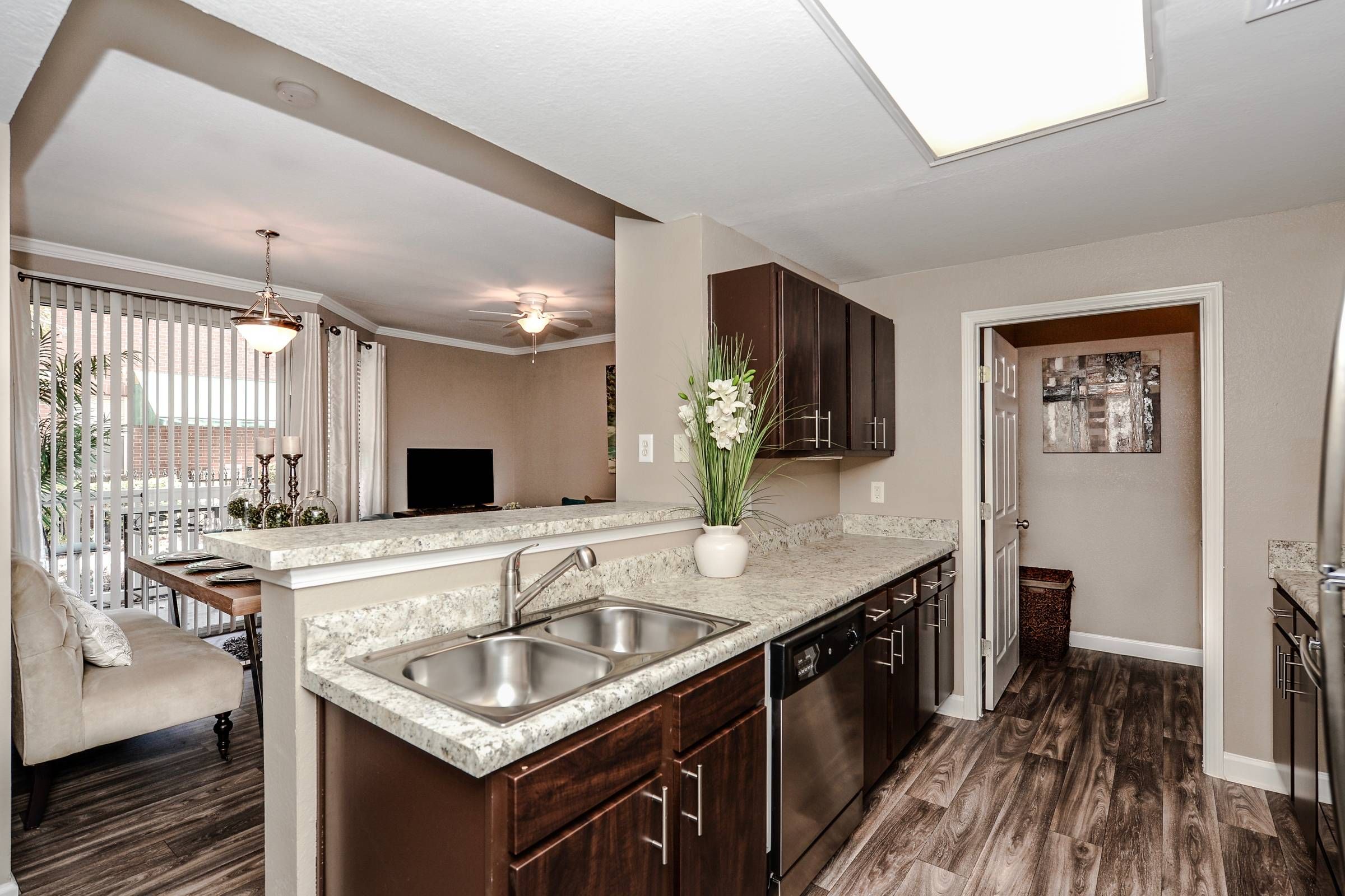 Altera Riverside kitchen with dark wood cabinets, granite counters, and stainless steel appliances.