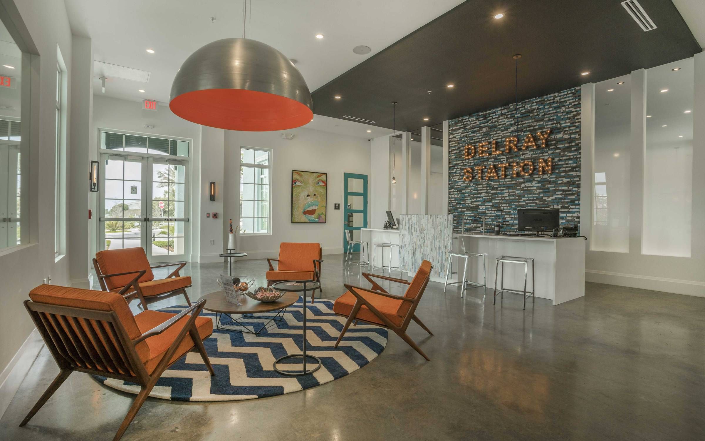 Delray Station clubhouse lounge area with seating, welcome desk, and retro decorations.