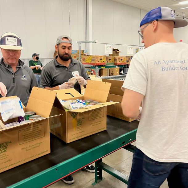 Men preparing boxes of food at a local food bank in a warehouse