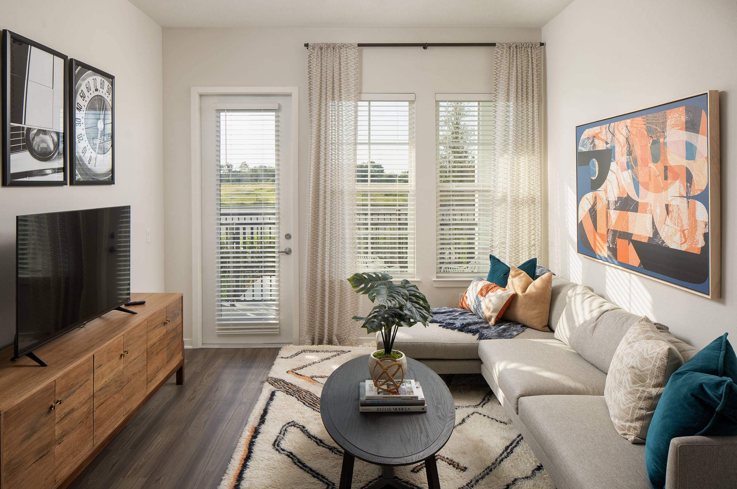 Bright and inviting living room at Alta Winter Garden with comfortable seating, a round coffee table, and vibrant wall art under natural light.