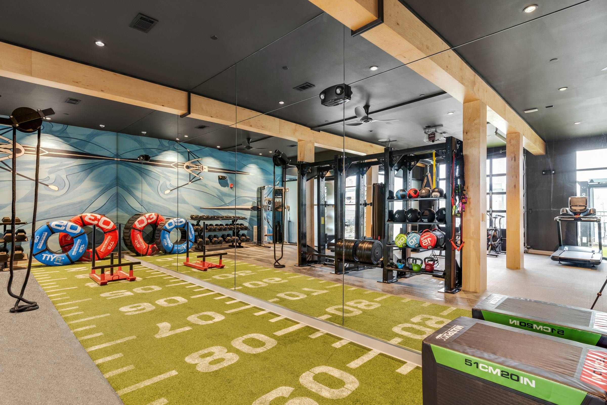 Alta Riverwalk fitness center with workout equipment and football-themed rug.