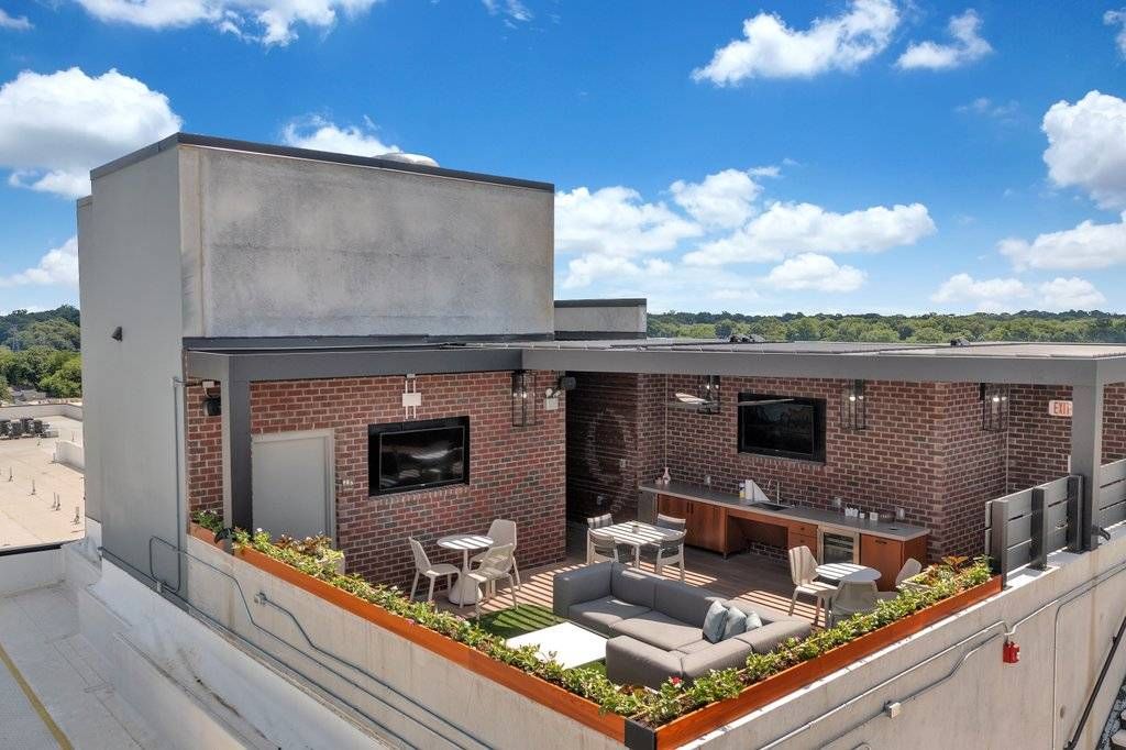 Alta Purl outdoor community kitchen and lounge area with astro-turf and ample seating on rooftop.