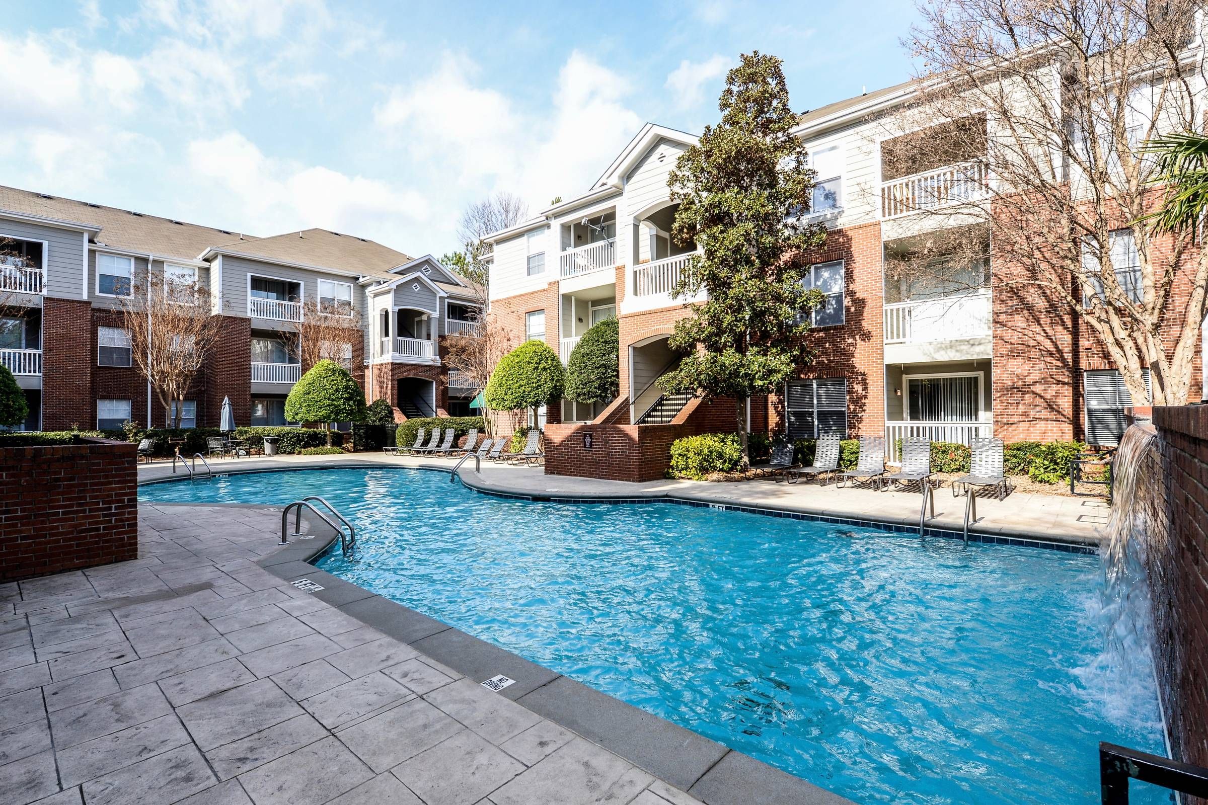 Altera Riverside apartments in front of community pool and lounge chairs.