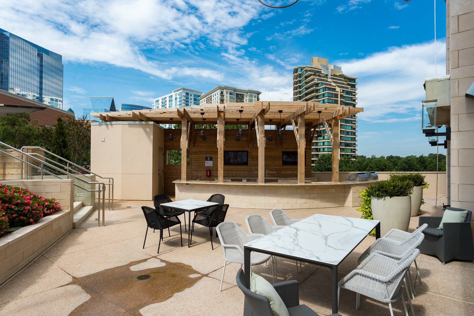 The Huntley outdoor bar/grilling area under canopy with dining tables.