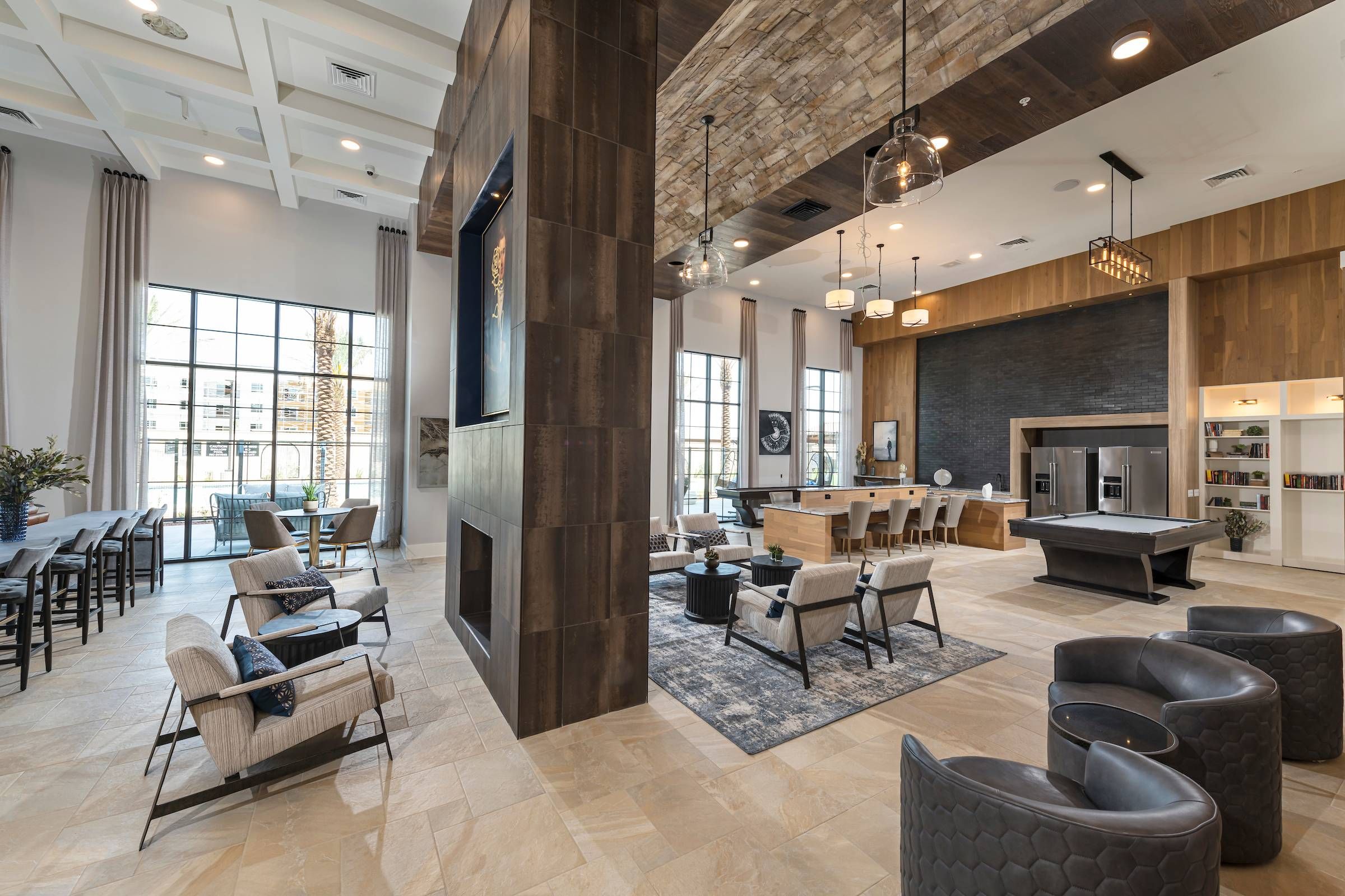 A stylish common area at Alta Southern Highlands with a fireplace, wooden beams on the ceiling, and modern furniture.