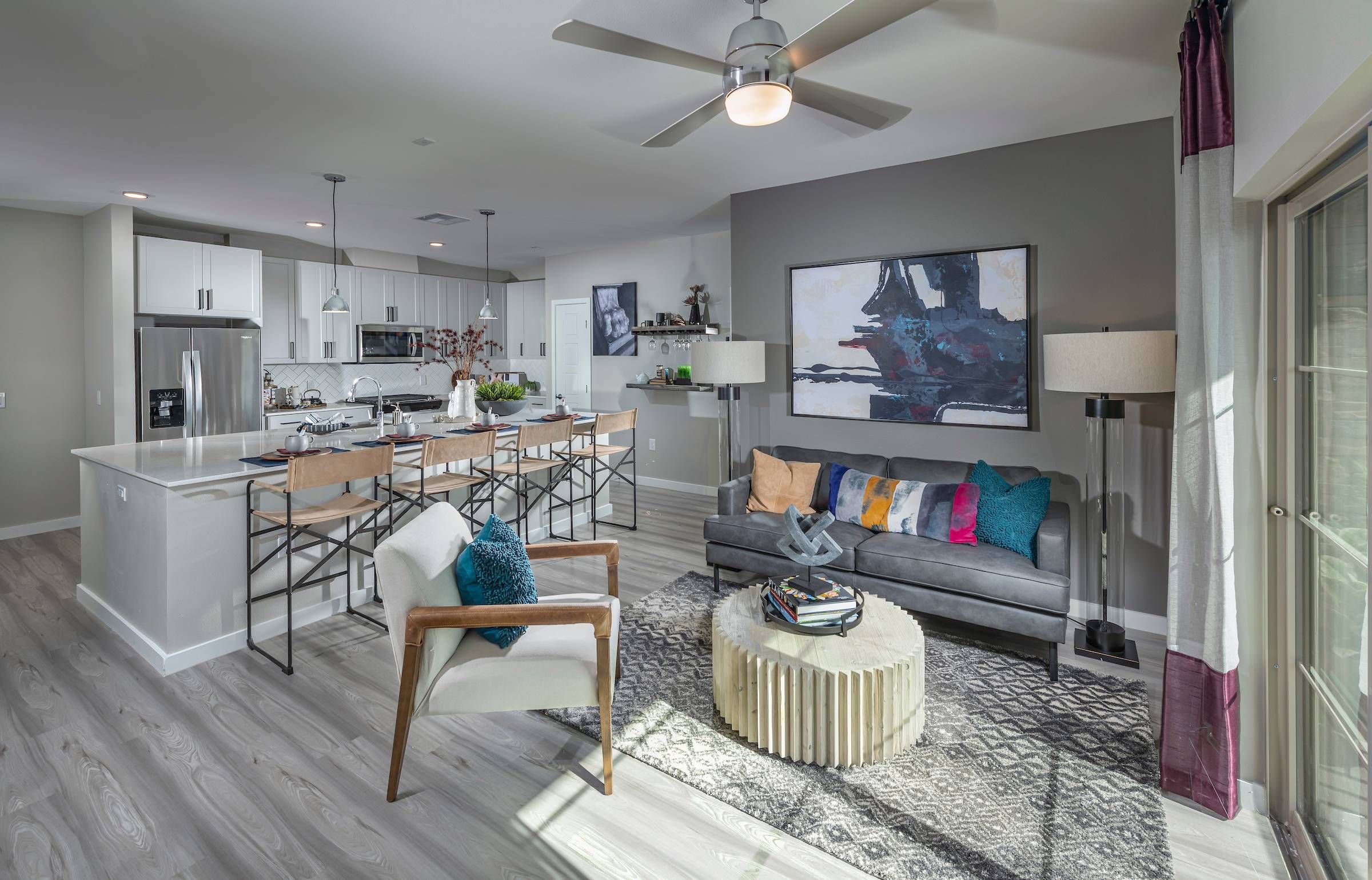 An open-plan living and dining area at Alta Southern Highlands with contemporary furnishings and kitchen in the background.
