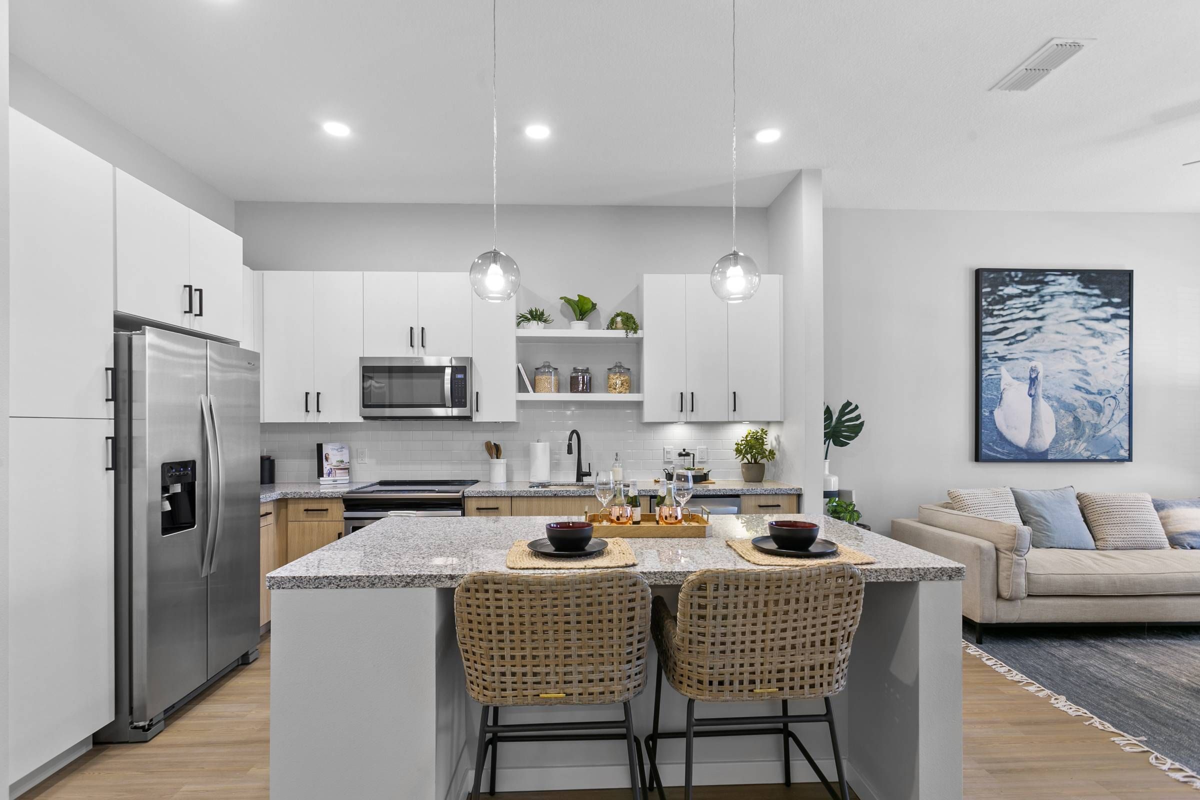 Alta Belleair's kitchen and dining space, boasting minimalist design, clean white surfaces, and a dining area that opens into the inviting living room.