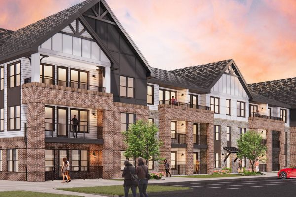 Exterior of Alta Stone apartment building with people walking by and a sunset sky