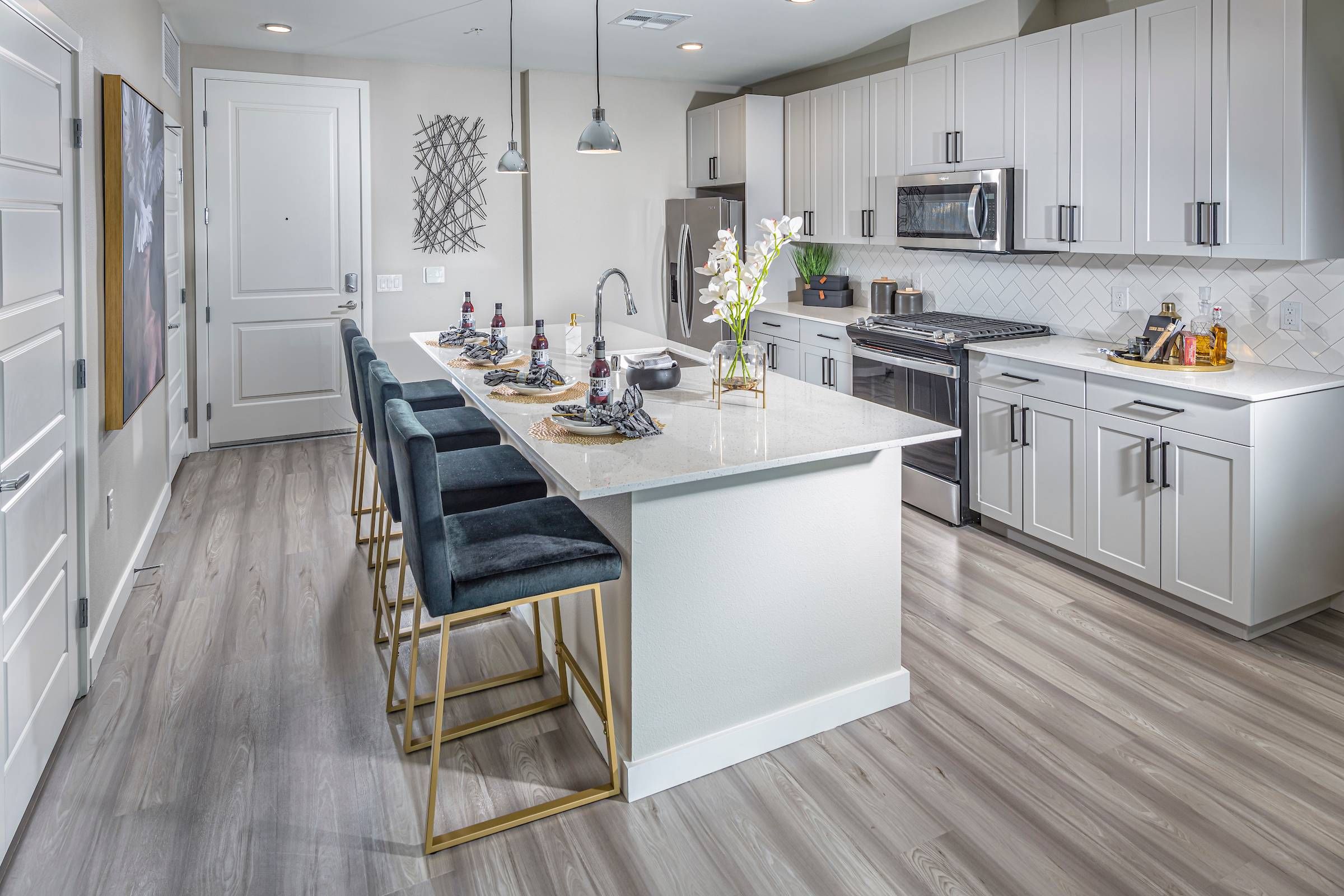 A spacious, modern kitchen with a bar seating area at Alta Southern Highlands is highlighted in this image.